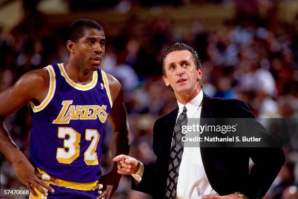 Magic Johnson of the Los Angeles Lakers talks with head coach Pat Riley during a game against the New York Knicks, circa 1990 at Madison Square...