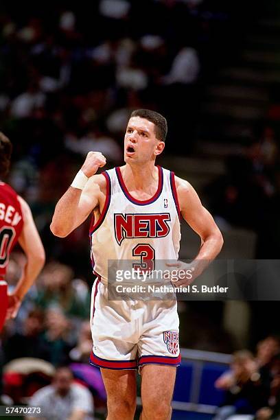 Drazen Petrovic of the New Jersey Nets pumps his fist against Bobby Hansen of the Chicago Bulls during a game in 1991 at Brendan Byrne Arena in East...