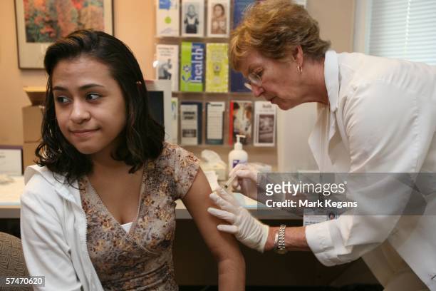 University of Iowa junior Erica Zamudil receives a mumps, measles and rubella vaccination shot from nurse Jan Bush at the school's Student Health...