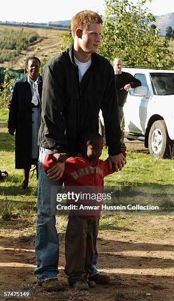 Prince Harry stands with an old friend, Mutsu Potsane, in the grounds of the Mants'ase children's home while on a return visit to Lesotho on April...