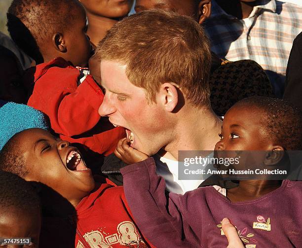 Prince Harry makes faces at children Mutsu and Lintle , in the grounds of the Mants'ase children's home while on a return visit to Lesotho on April...