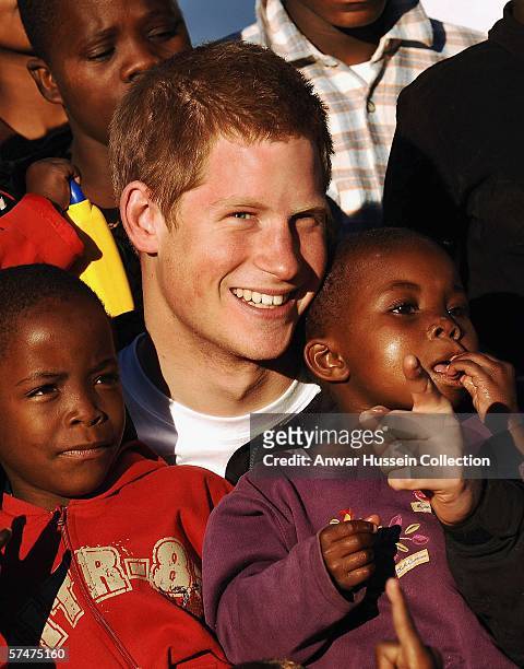 Prince Harry cuddles children Mutsu and Lintle , in the grounds of the Mants'ase childrens home while on a return visit to Lesotho on April 24, 2006...