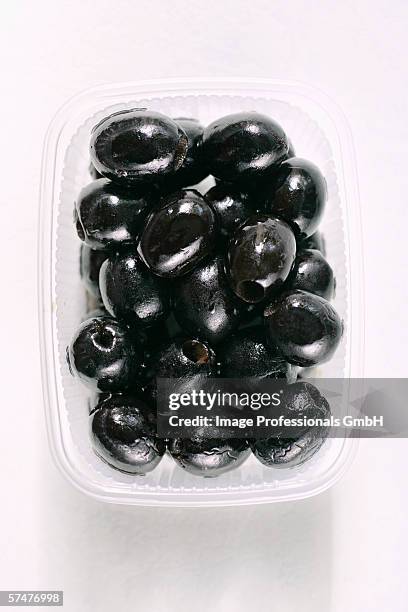 stoned black olives in a plastic container - black olive stock pictures, royalty-free photos & images