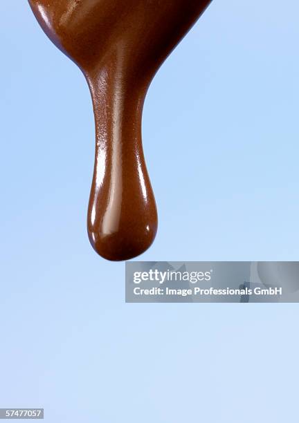 chocolate dripping from a spoon - fließend stock-fotos und bilder