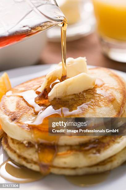 pouring maple syrup over pancakes with dab of butter - butter curl stock pictures, royalty-free photos & images