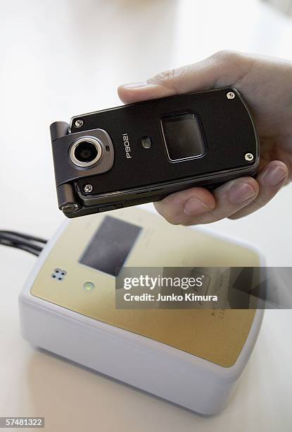 DoCoMo's phone based credit card is placed on a reader at a cafe on April 28, 2006 in Tokyo, Japan. The Japanese communications carrier launches its...