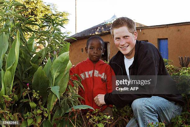 Britain's Prince Harry with old friend Mutsu Potsane inspect the Peach Tree that they planted in the grounds of the Mants'ase childrens home in March...