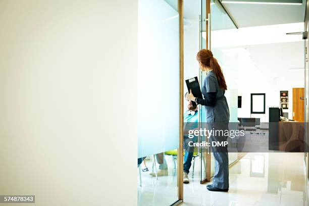 krankenschwester im gespräch mit patienten im wartezimmer - dentist waiting room stock-fotos und bilder