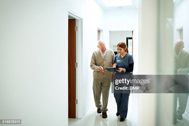 krankenschwester teilt medizinischen bericht mit senior-patienten - reading england stock-fotos und bilder