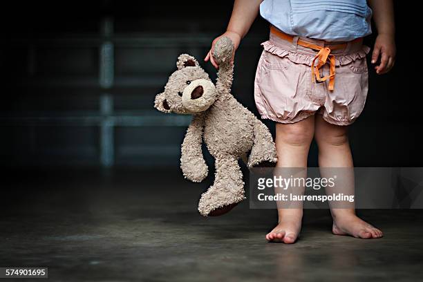 low section of a girl holding her teddy bear - nursery school child fotografías e imágenes de stock