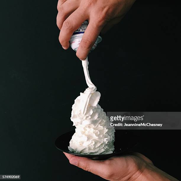 hand holding a plate with whipped cream - room stockfoto's en -beelden