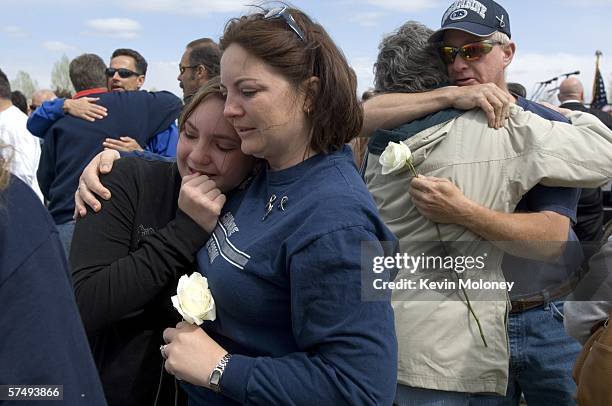 Coni Sanders daughter of slain teacher Dave Sanders, hugs her daughter Mallory as Bob Curnow father of victim Steven Curnow, embraces a friend at a...