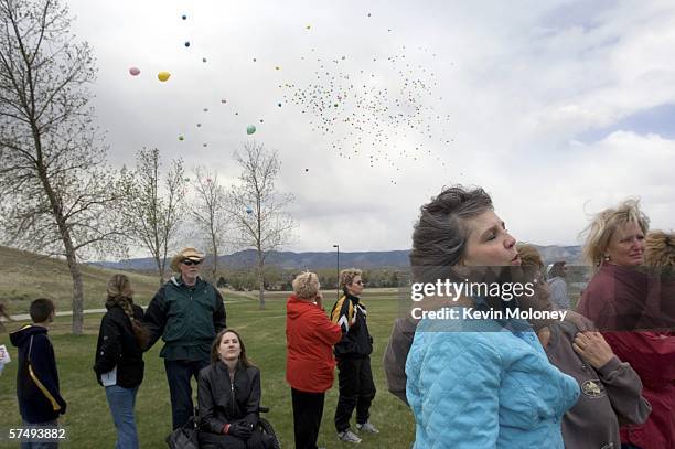 Patricia DePooter, mother of Columbine shooting victim Corey DePooter sings with memorial committee member Ruth Fekdman as balloons are released at a...