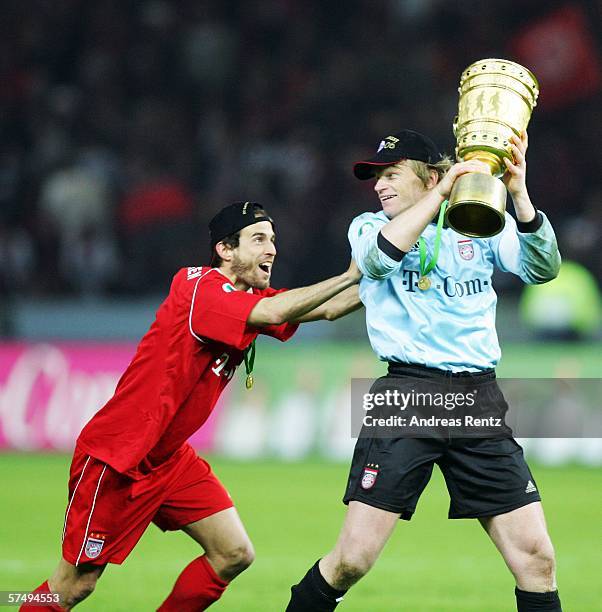 Mehmet Scholl of Bayern Munich and team mate Oliver Kahn joke with the trohy after winning the DFB German Cup final between Bayern Munich and...