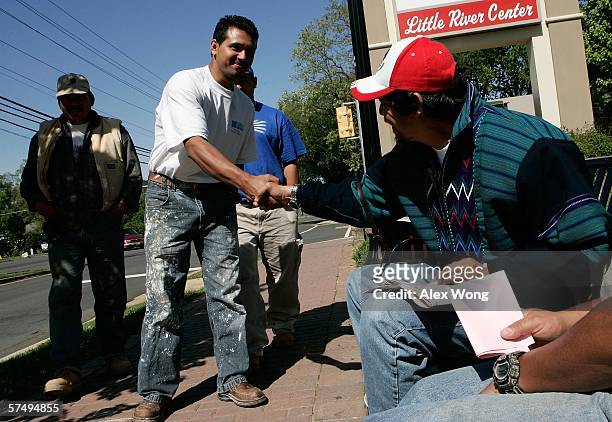 Arnoldo Borja , a community organizer of Virginia Justice Center, greets Latino day laborers who stand along Little River Turnpike waiting for...