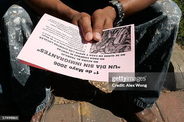 Latino day laborer reads a May 1st boycott flyer handed out by Arnoldo Borja, a community organizer of Virginia Justice Center, on Little River...