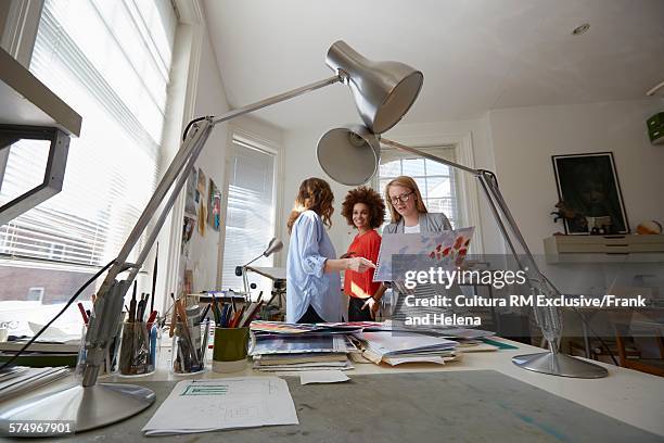 designers discussing project in office - rm creatief stockfoto's en -beelden