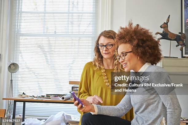 designer using smartphone in office - rm creatief stockfoto's en -beelden