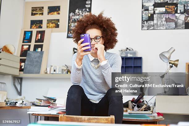 designer using smartphone in office - rm creatief stockfoto's en -beelden