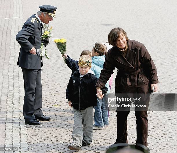 King Carl XVI Gustaf of Sweden recieves presents from children on his 60th Birthday during the changing of the guard at the Stockholm Royal Palace on...