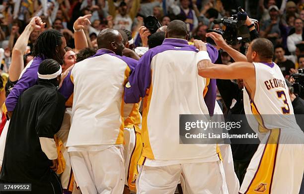 The Los Angeles Lakers swarm Kobe Bryant of the Lakers after he hit the game-winning shot in overtime against the Phoenix Suns in Game Four of the...