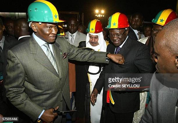 Senegalese President Abdoulaye Wade sticks a piece of inaugural ribbon late 30 April 2006 in the pocket of Dakar Mayor Pape Diop after inaugurating...