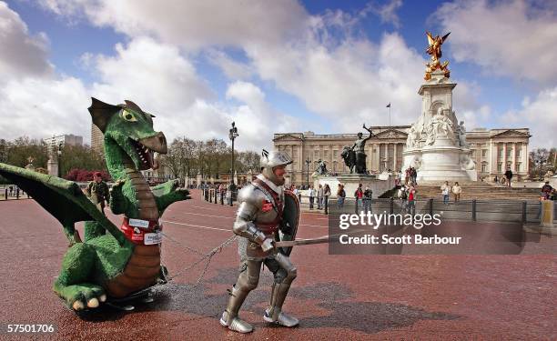 Charity fundraiser Lloyd Scott, dressed in a full suit of armour weighing 100 pounds and dragging a 10 foot dragon weighing 200 pounds runs past...