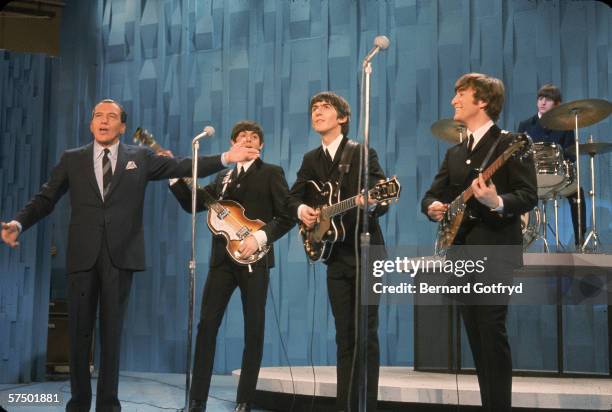 View of American television personality Ed Sullivan , with the members of British Rock group the Beatles, during an episode of 'The Ed Sullivan Show'...