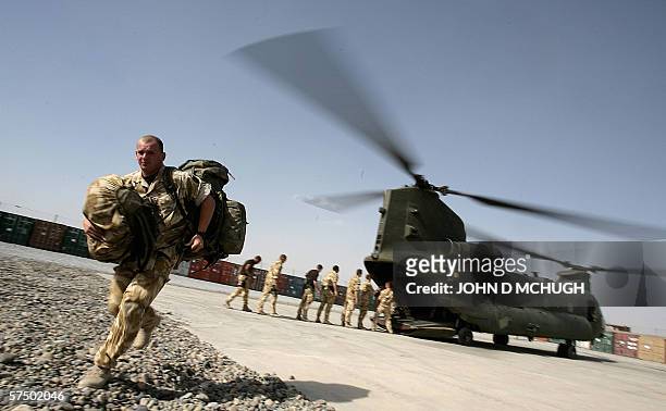 Lashkar Gah, AFGHANISTAN: British soldiers unload passengers and supplies from a Chinook helicopter at the Provincial Reconstruction Team base at...