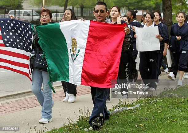 Demonstrators carry a Mexican and a United States flag while marching May 1, 2006 in Chicago, Illinois. Immigrants and their supporters around the...