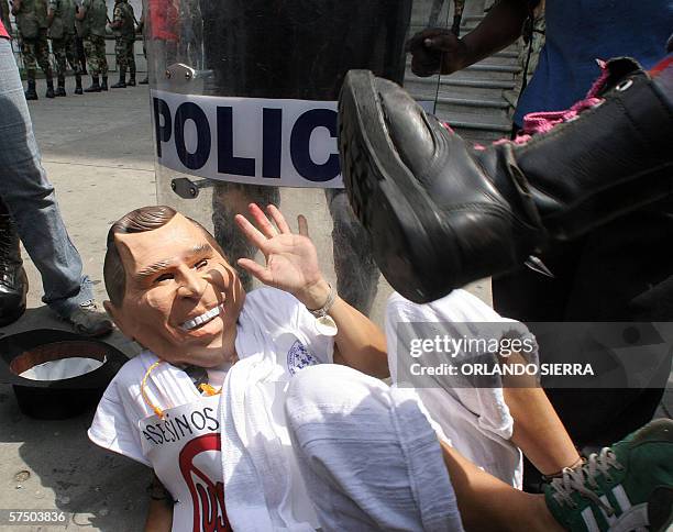 Una mujer amenaza golpear a un hombre que representa al presidente de los Estados Unidos George W. Bush, mientras participa en una marcha durante el...