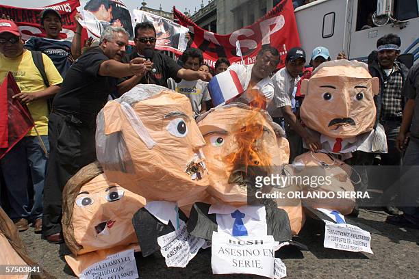 Trabajadores queman monigotes de lideres mundiales y guatemaltecos, entre ellos el presidente de los Estados Unidos George W. Bush, durante una...