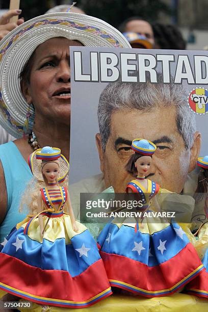 Una opositora al presidente venezolano Hugo Chavez participa de la manifestacion del Dia del Trabajador con un afiche alusivo al presidente de la...