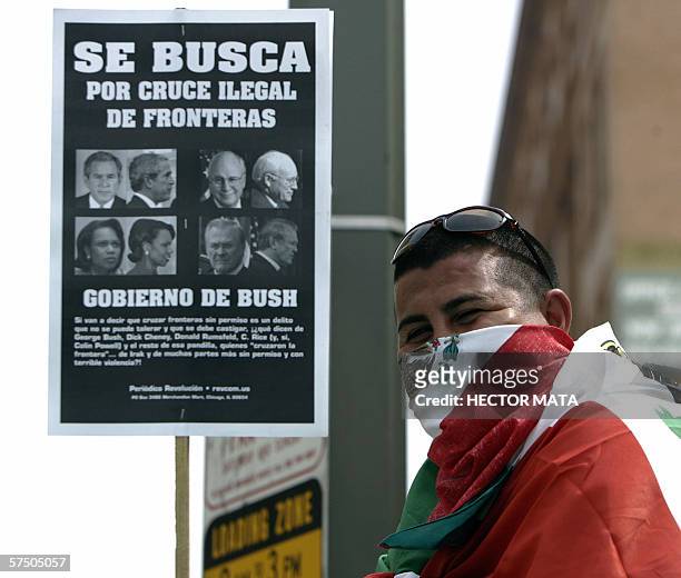 Los Angeles, UNITED STATES: A man covers his faced with a Mexican flag during a large demonstratration in downtown Los Angeles 01 May 2006. Organized...