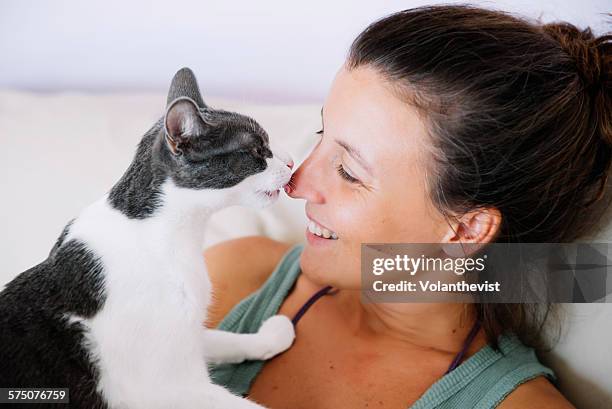 cute femane cat licking her happy owner - huisdiereigenaar stockfoto's en -beelden