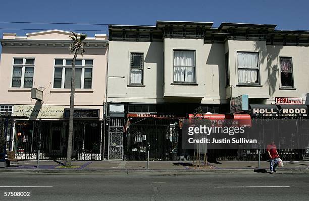 People walk by a row of closed businesses in the Mission District as store owners elected to closed their businesses to protest for immigrant rights...