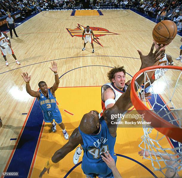 Troy Murphy of the Golden State Warriors shoots past Marc Jackson of the Charlotte Hornets during the game at the Arena in Oakland in Oakland,...