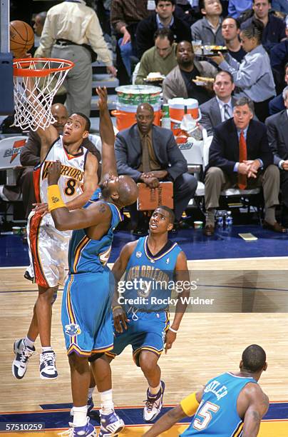 Monta Ellis of the Golden State Warriors shoots against Marc Jackson and Chris Paul of the Charlotte Hornets during the game at the Arena in Oakland...