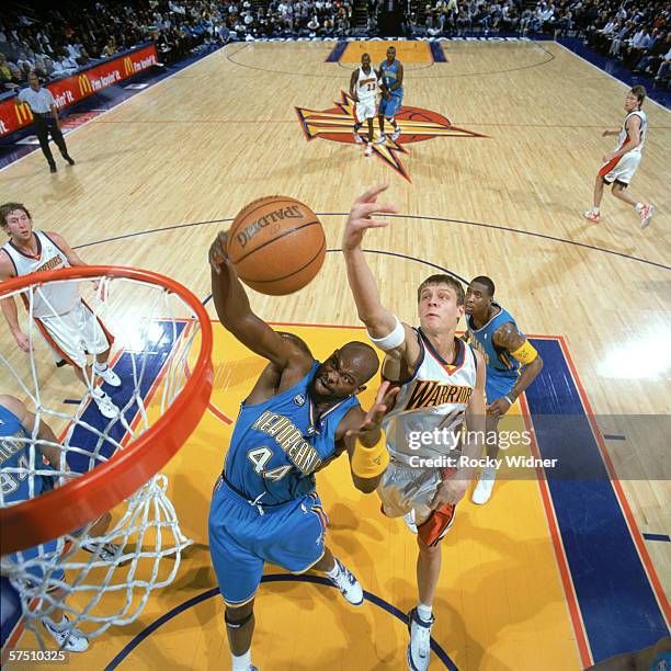 Marc Jackson of the Charlotte Hornets and Andris Biedrins of the Golden State Warriors attempt to rebound the ball during the game at the Arena in...