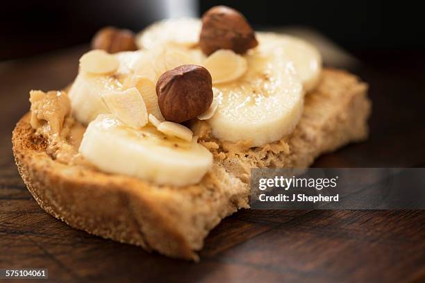 peanut butter, banana and nuts on toast - peanut butter toast stock pictures, royalty-free photos & images