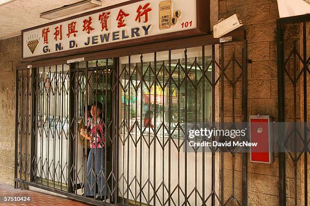 Woman locks the bars protecting her business in China Town several blocks from City Hall where a rally is about to begin on what is dubbed a "Day...