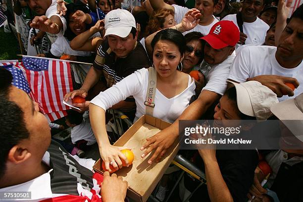 Man passes orange out to the crowd to keep them refreshed during a march and rally on what is dubbed a "Day Without Immigrants" or the "Great...