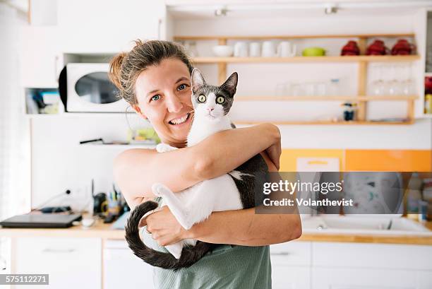 beautiful woman holding a cute cat at home - cat lady stock pictures, royalty-free photos & images