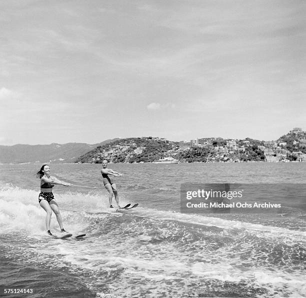 Two women water ski off the beach in Acapulco, Mexico.