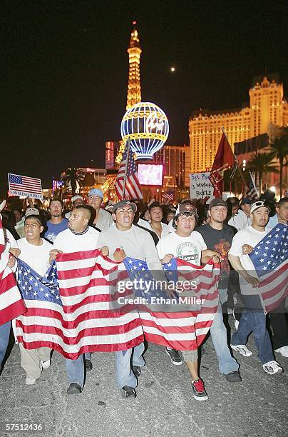 The Paris Las Vegas is seen behind people marching down the Las Vegas Strip in support of immigrant rights as part of a "Day Without Immigrants" on...