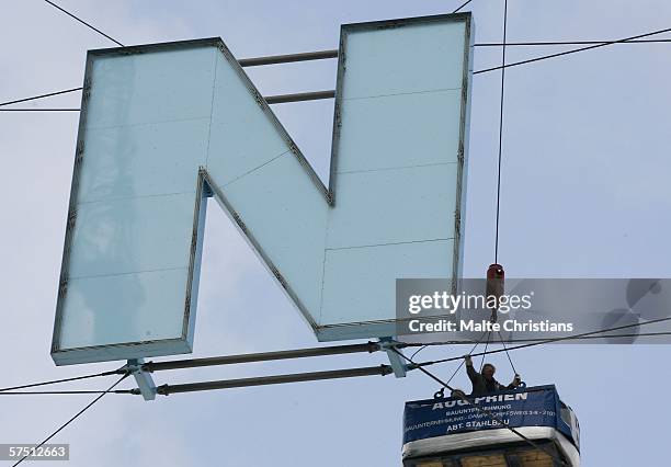 Crane lifts up workers to the letter "N" of the AOL Arena, carrying away the name of the sponsor on May 2, 2006 in Hamburg, Germany. The name of the...