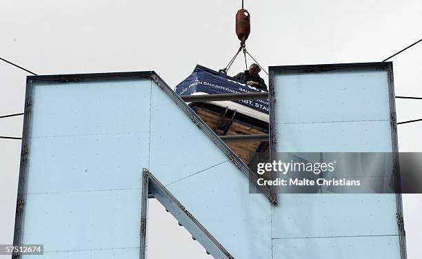 Crane lifts up worker to the letter "N" of the AOL Arena, carrying away the name of the sponsor on May 2, 2006 in Hamburg, Germany. The name of the...