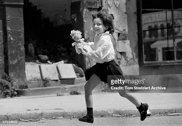 Smiling child runs across 'Sniper Alley' in Sarajevo during heavy fighting in 1993.
