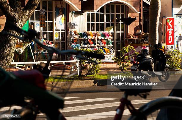 bicycles and mopeds: the preferred transportation in touristy ogasawara village. - chichijima stock pictures, royalty-free photos & images