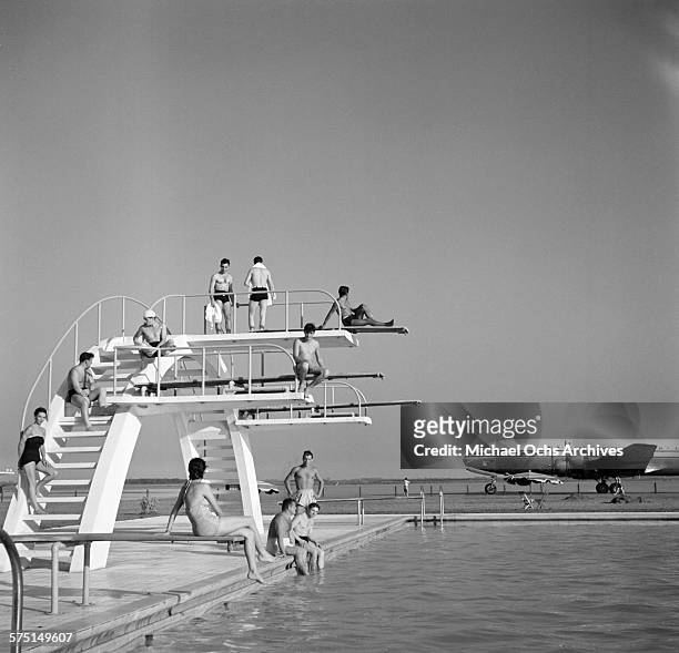 View of an Pan American Airways DC-4 Clipper airplane on the tarmac as people swim in a swimming pool at the Ezeiza Airport in Buenos Aires,...